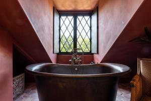 a bath tub in a room with a window at The Notary in Bruges