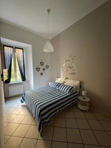 ein Schlafzimmer mit einem Bett mit einer blau-weiß gestreiften Decke in der Unterkunft Casa MaVi in Neapel