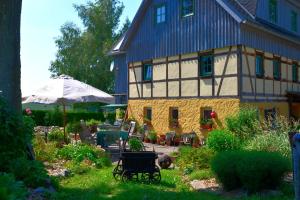 a large house with a garden in front of it at Hotel Olbernhau mit Sauna - Kleines Landhotel zur Ofenschenke in Olbernhau