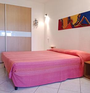 a bedroom with a large pink bed in a room at Le case di Lidia due appartamenti con piscina e accesso diretto al mare in Castelsardo +59 photos