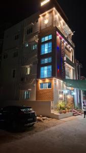 a tall building with blue lights on it at night at Roshni Apartment - 3A in Vishāram