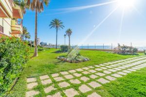 chodnik w pobliżu plaży z palmami i oceanem w obiekcie Casa Linda, Front the beach La Lucera, Ribiera del Sol Wifi, AC, Private Parking, Petfriendly w mieście Sitio de Calahonda