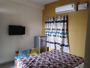a room with a bed and a tv in a room at Roshni Apartment - 3A in Vishāram