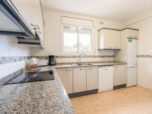 a kitchen with white cabinets and a sink at Holiday Home Canción de mar by Interhome in Creixell