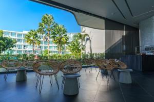 a group of chairs and tables on a balcony at Super Studio La Vita 2 pool in Rawai Beach