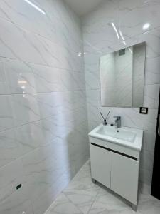 a white bathroom with a sink and a mirror at RENTSUITE SPACIOUS and COMFY 2 BEDROOM in Marrakech