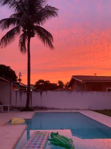 グアルジャにあるCasa da Piscinaのヤシの木と夕日を望むスイミングプール