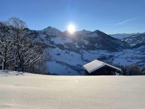 una montaña cubierta de nieve con el sol en el fondo en Apartment Heimersberg by Interhome, en Zweisimmen