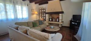 een woonkamer met een bank en een tv bij La Tour de Véra in Auriac-du-Périgord