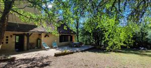 een patio met 2 stoelen en een tafel voor een huis bij La Tour de Véra in Auriac-du-Périgord