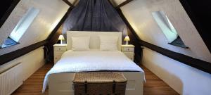 een slaapkamer met een bed en twee ramen bij La Tour de Véra in Auriac-du-Périgord