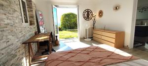 Un dormitorio con una cama y un escritorio y una ventana. en Echappee-Belle, en Badefols-dʼAns