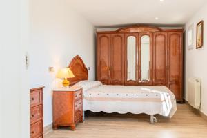 a bedroom with a wooden bed and a dresser at Kalacandi in Cunit +42 photos