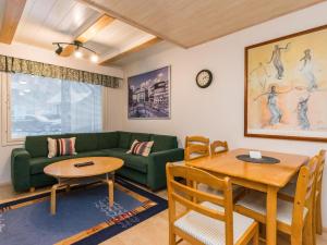 a living room with a green couch and a table at Holiday Home Kylpylän ullanrinne 12 d by Interhome in Ikaalinen