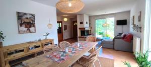 a dining room and living room with a table and chairs at Le Refuge des libellules in Daglan