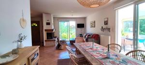 a kitchen and living room with a table and chairs at Le Refuge des libellules in Daglan