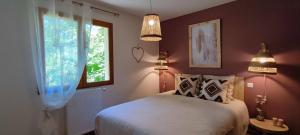 a bedroom with a bed and two lamps and a window at Le Refuge des libellules in Daglan +49 photos