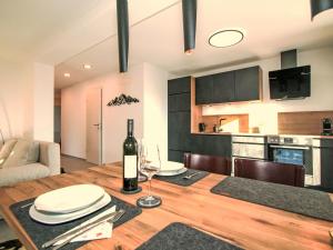 a dining room and kitchen with a table with a bottle of wine at Apartment Wibmer by Interhome in Axams
