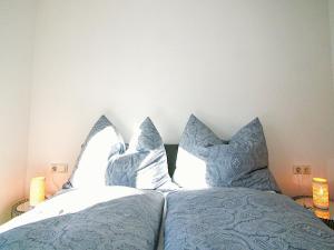 a bed with blue and white pillows on it at Apartment Wibmer by Interhome in Axams +13 photos