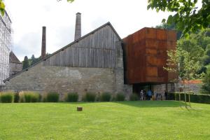 eine alte Steinkirche mit einem großen Holzgebäude in der Unterkunft Le Sel J'm in Salins-les-Bains
