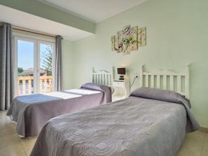 two beds in a bedroom with a balcony at Holiday Home Villa Tos by Interhome in Sa Coma