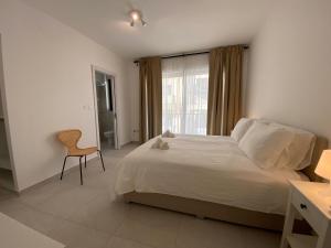 una camera da letto con un letto, una sedia e una finestra di Swieqi Malaika New Apt 3 a Is-Swieqi