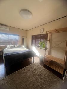 a bedroom with a bed and a window with a clock at base-k49 in Tenri +12 photos