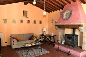 a living room with a couch and a fireplace at Podere Casato 2 Hills View, Pool, Wifi Tuscany in Montespertoli