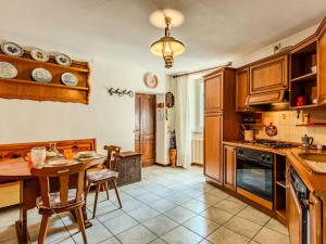 a kitchen with wooden cabinets and a table and chairs at Apartment Vista Cascata by Interhome in Nesso