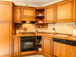 a kitchen with wooden cabinets and a stove at Apartment Vista Cascata by Interhome in Nesso