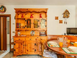a kitchen with a wooden cabinet and a table at Apartment Vista Cascata by Interhome in Nesso +21 photos