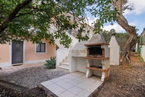 a white house with a fireplace in the yard at T1 Apartamentos Vista Alegre in Albufeira