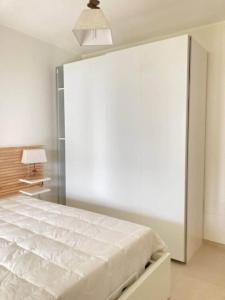 ein weißes Schlafzimmer mit einem Bett und einer großen Wand in der Unterkunft Villa Jolanda - Costa degli Dei in Zambrone