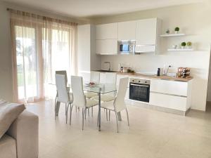 a kitchen with a glass table and white chairs at Villa Jolanda - Costa degli Dei in Zambrone