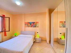 a bedroom with a white bed and two lights on two tables at Armonia Machiavelli House Gallipoli in Gallipoli