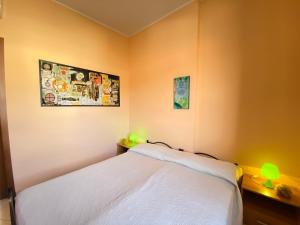 a bedroom with a white bed and two lamps at Armonia Machiavelli House Gallipoli in Gallipoli