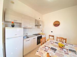 a kitchen with a table and a white refrigerator at Armonia Machiavelli House Gallipoli in Gallipoli