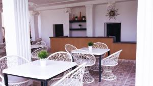 uma fila de mesas e cadeiras brancas num quarto em Hotel Marimba Punta Cana em Punta Cana
