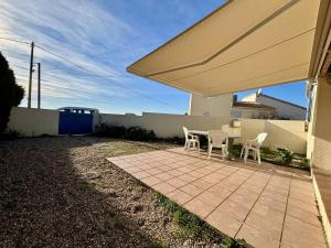 a patio with a table and chairs under a white umbrella at Maison 3 pièces 4 couchages SAINT DENIS D'OLERON - SDO000-058 in Saint-Denis-dʼOléron +8 photos