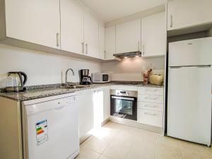 une cuisine avec des armoires blanches et un réfrigérateur blanc dans l'établissement Holiday Home Colores al Mar by Interhome, à La Vila Joiosa