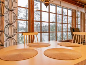 Una mesa de comedor con cuatro sillas y una gran ventana. en Holiday Home Saaga by Interhome, en Ylöjärvi