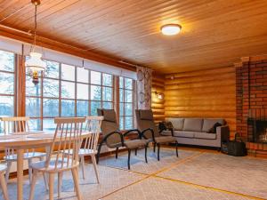 Una sala de estar con mesa y sillas y una chimenea. en Holiday Home Saaga by Interhome, en Ylöjärvi