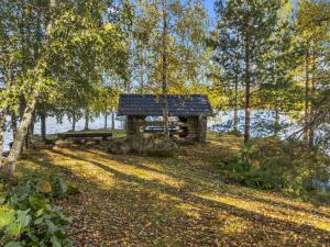 a log cabin in the woods next to a lake at Holiday Home Laura by Interhome in Outokumpu