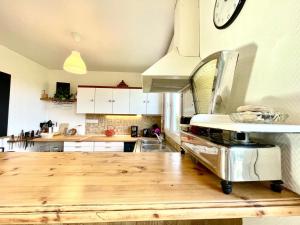 een keuken met een houten aanrecht met een klok aan de muur bij Maison de la plage Santec in Santec