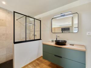 a bathroom with a sink and a mirror at Holiday Home L'Aventure Gouvillaise by Interhome in Gouville-sur-Mer