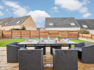 a patio with a table and chairs on a deck at Holiday Home L'Aventure Gouvillaise by Interhome in Gouville-sur-Mer