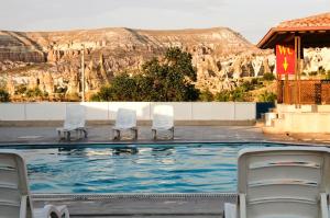 ein Pool mit Stühlen und ein Berg im Hintergrund in der Unterkunft Ciner Hotel in Goreme