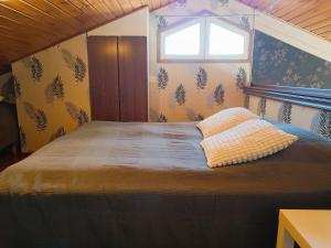 Un dormitorio con una cama grande con ventana. en Näköalahuoneisto 420, en Syöte