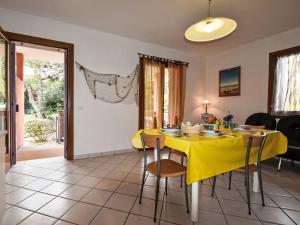 a dining room with a yellow table and chairs at Apartment Solmare-54 by Interhome in Rosapineta