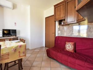 a living room with a red couch and a table at Apartment Mediterraneo-16 by Interhome in Rosapineta